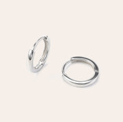 Lina white gold huggie earrings with a smooth minimalist finish, made in vermeil over sterling silver, lightweight and sweatproof by SILVBREEZE