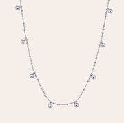 Lyric beaded necklace in white gold vermeil with floating silver beads on a dainty chain, crafted from sterling silver and perfect for athleisure layering by SILVBREEZE.