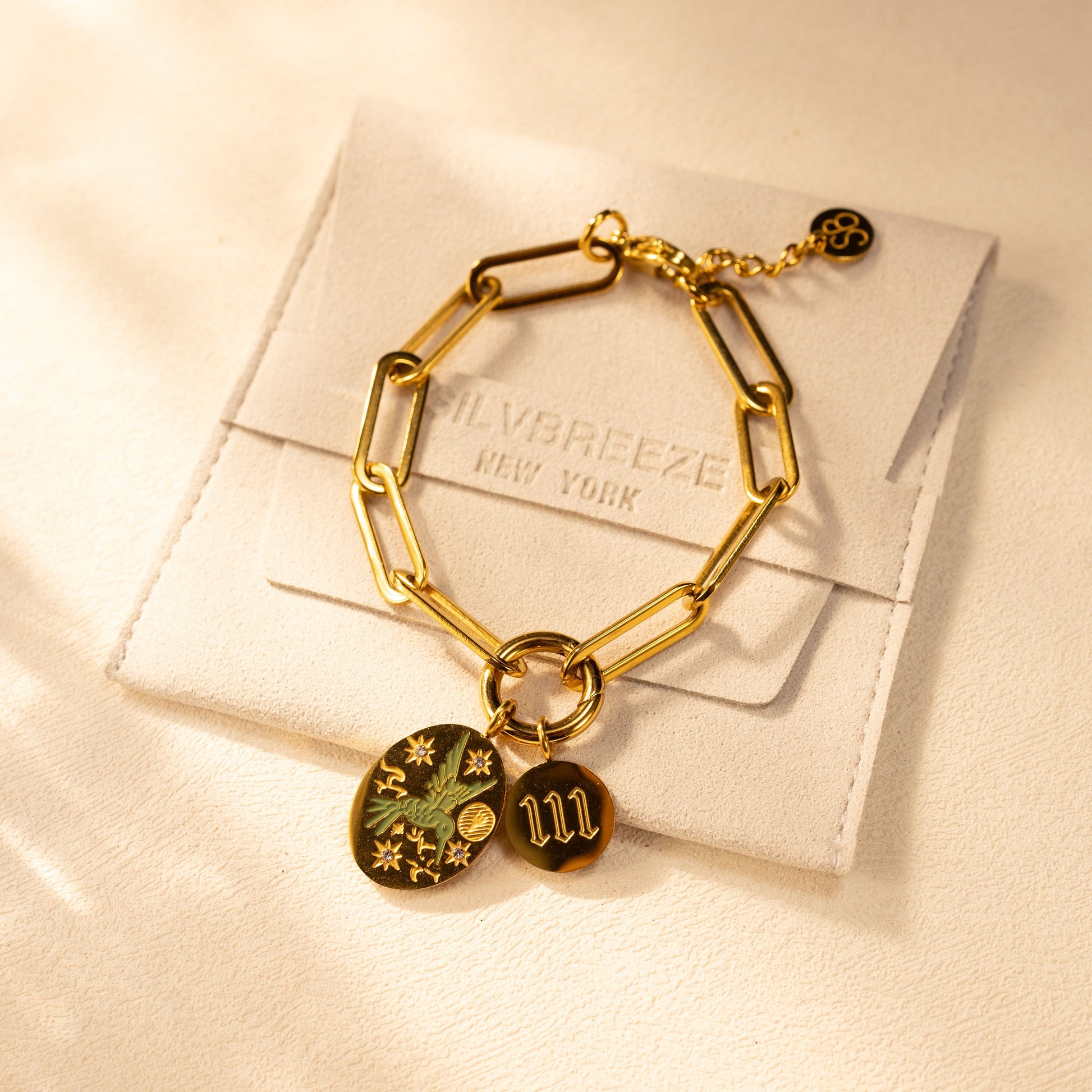 Silvbreeze Greenbird angel number 111 gold bracelet displayed on suede jewelry pouch.
