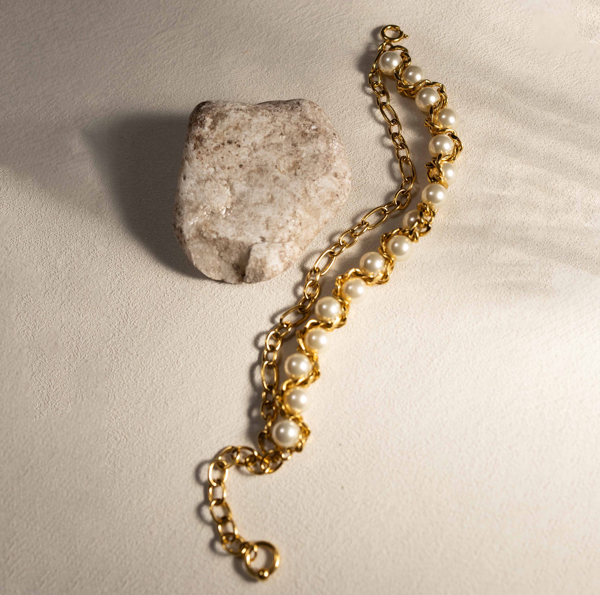 Detail view of Silvbreeze Apollo & Artemis gold-toned bracelet showing mother of pearl beads and polished stainless steel links