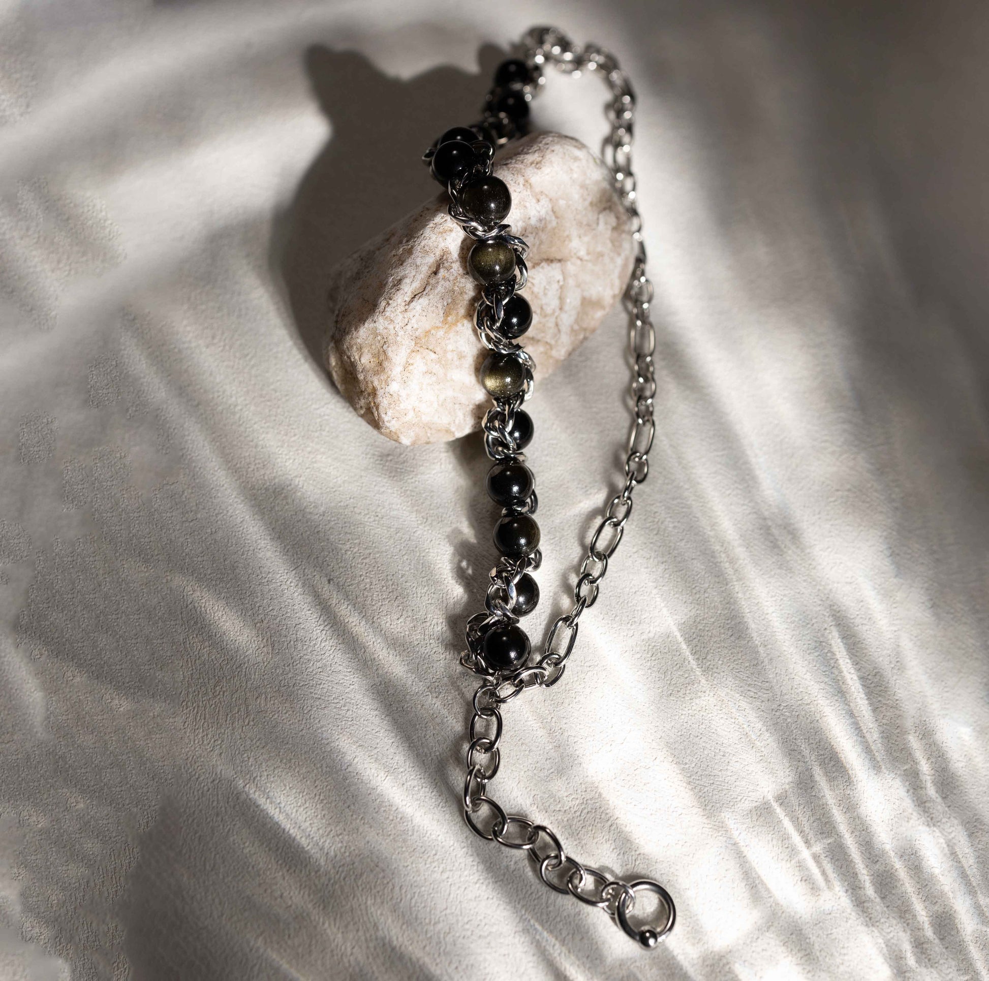 Close-up of Silvbreeze Apollo & Artemis bracelet highlighting golden obsidian stones and silver-toned stainless steel chain details