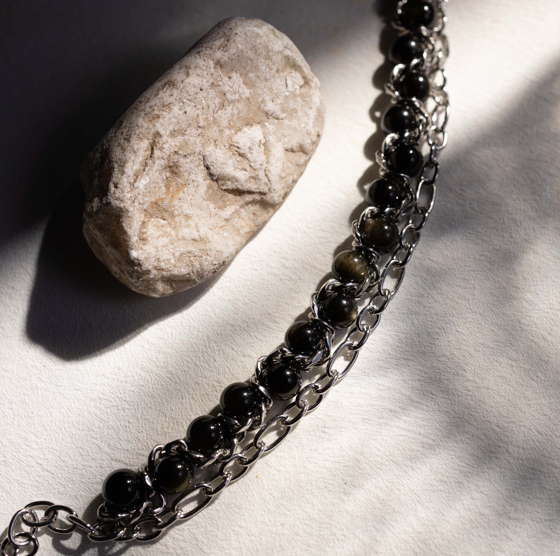 Silvbreeze Apollo & Artemis obsidian bracelet styled in natural light, symbolizing protection and boundary through a guardian-inspired design