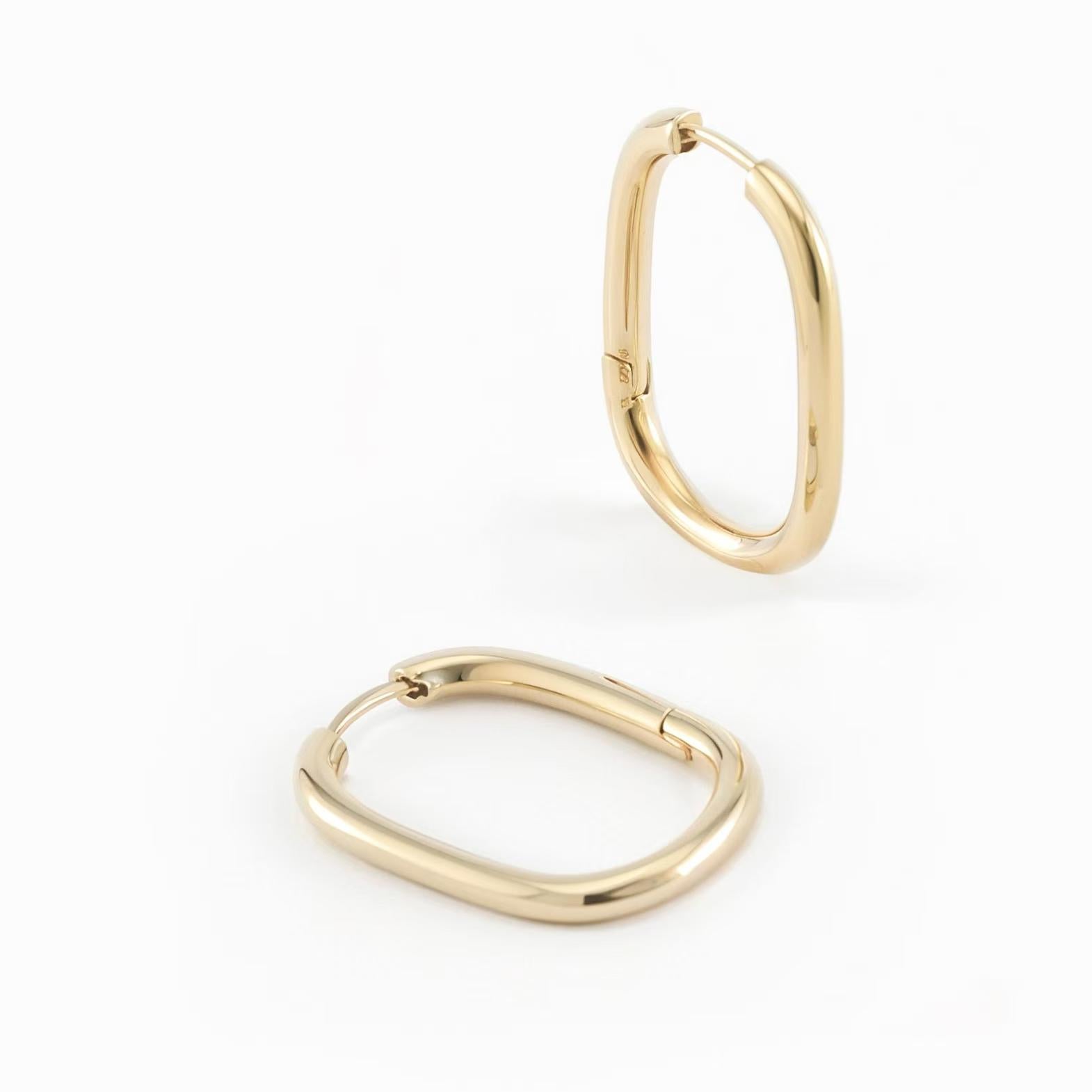 Silvbreeze Athena gold oval hoop earrings, sleek minimalist hinged hoops displayed on a clean white background