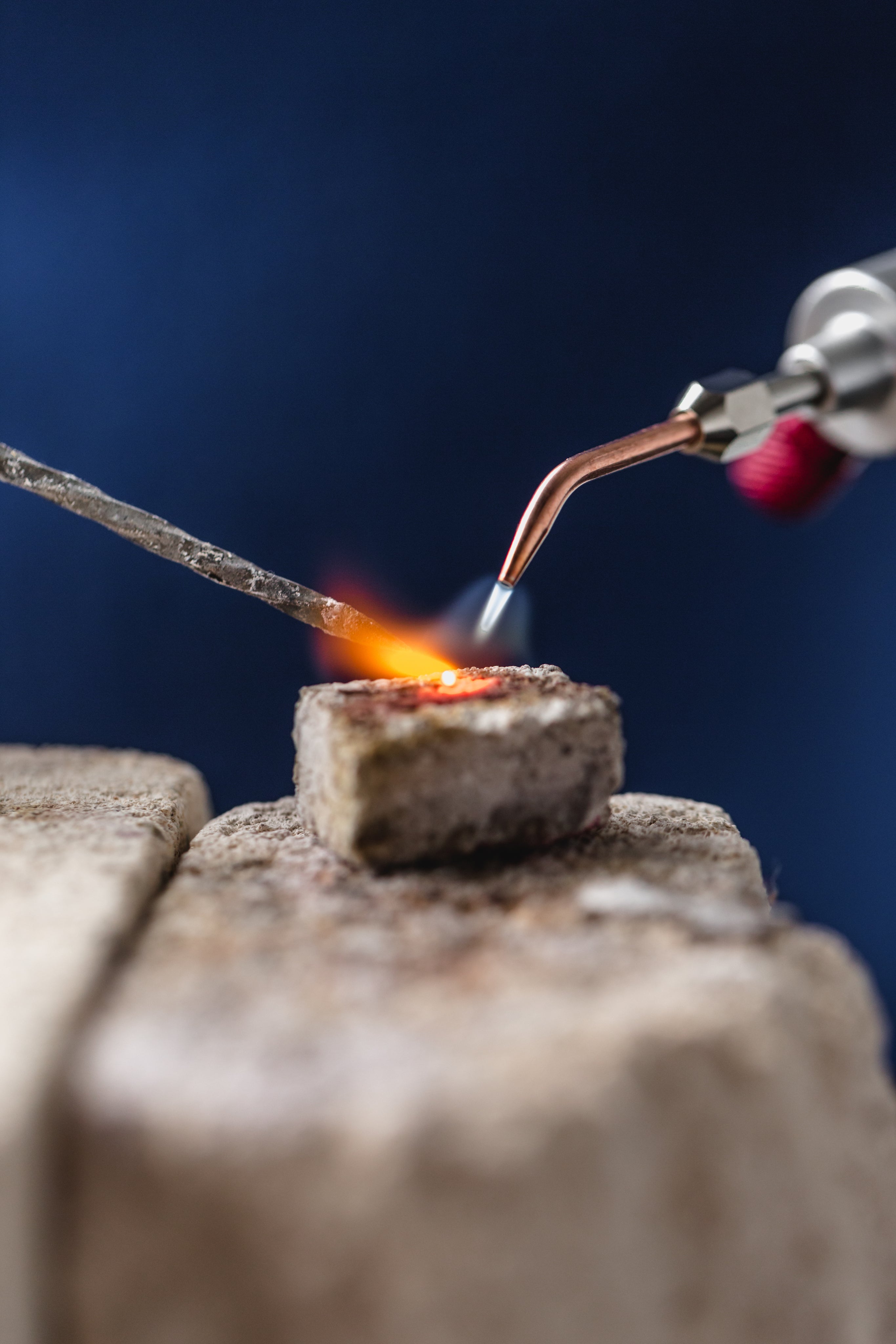 Close up of professional jewelry craftsmanship showing a torch soldering metal, highlighting Silvbreeze’s careful materials and high-quality production standards.
