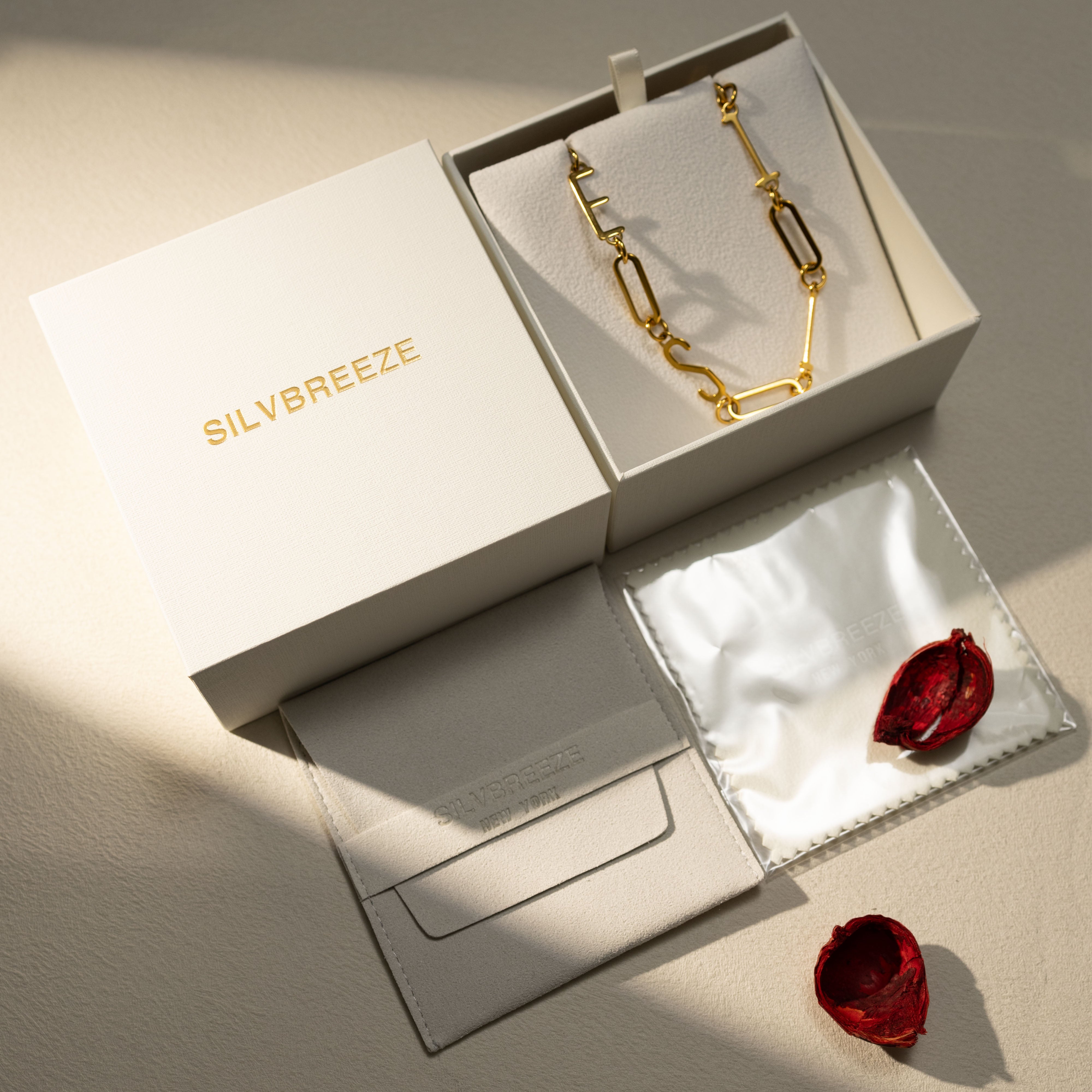 ESTJ 18K gold MBTI paperclip chain necklace displayed in an open Silvbreeze gift box with pouch and dried rose petals — gift-ready, perfect for romantic gifting to girlfriend or wife.