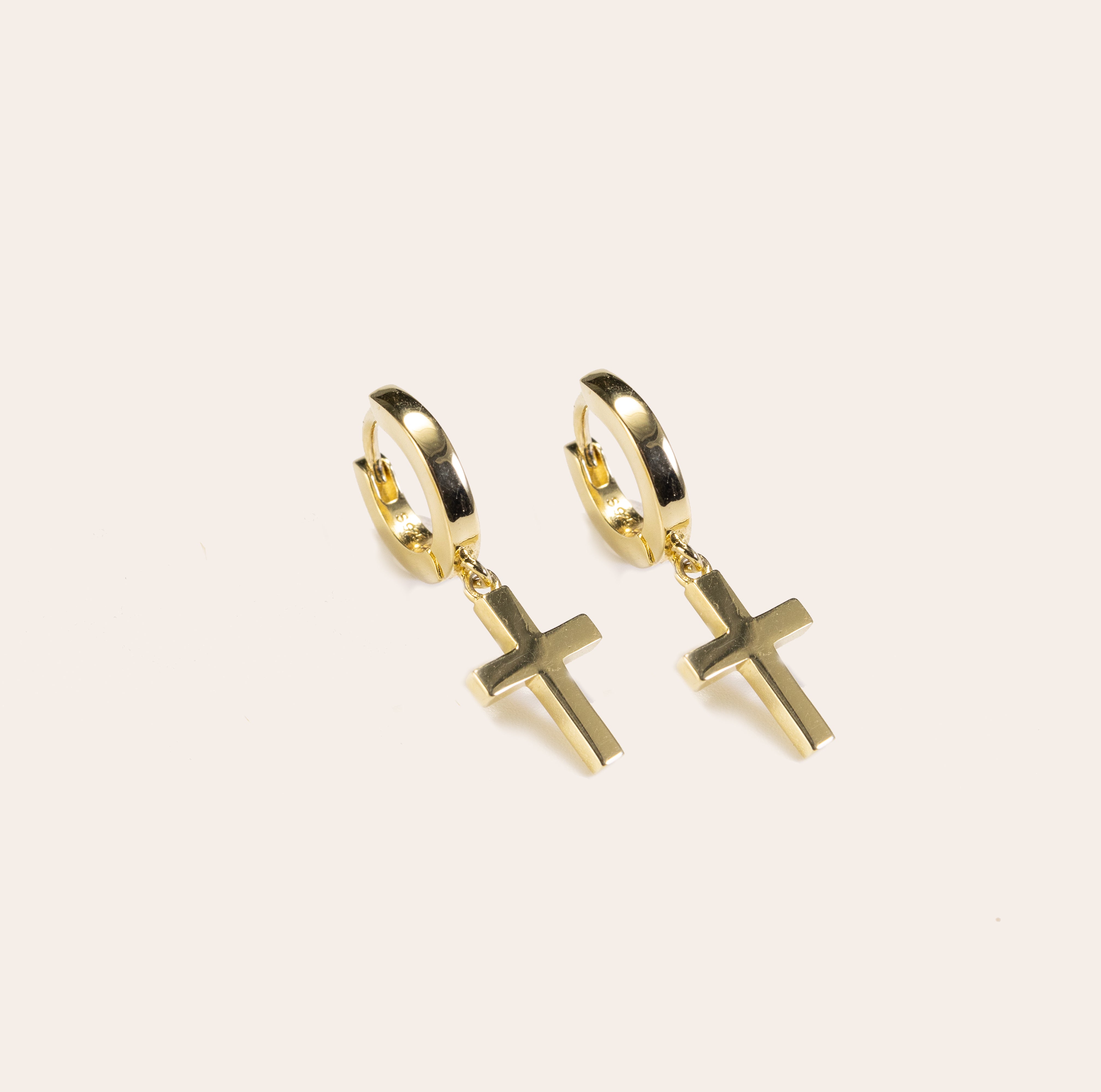 Gold vermeil cross huggie earrings by Silvbreeze shown on a clean white background, modern minimalist dangling cross hoop earrings for everyday wear