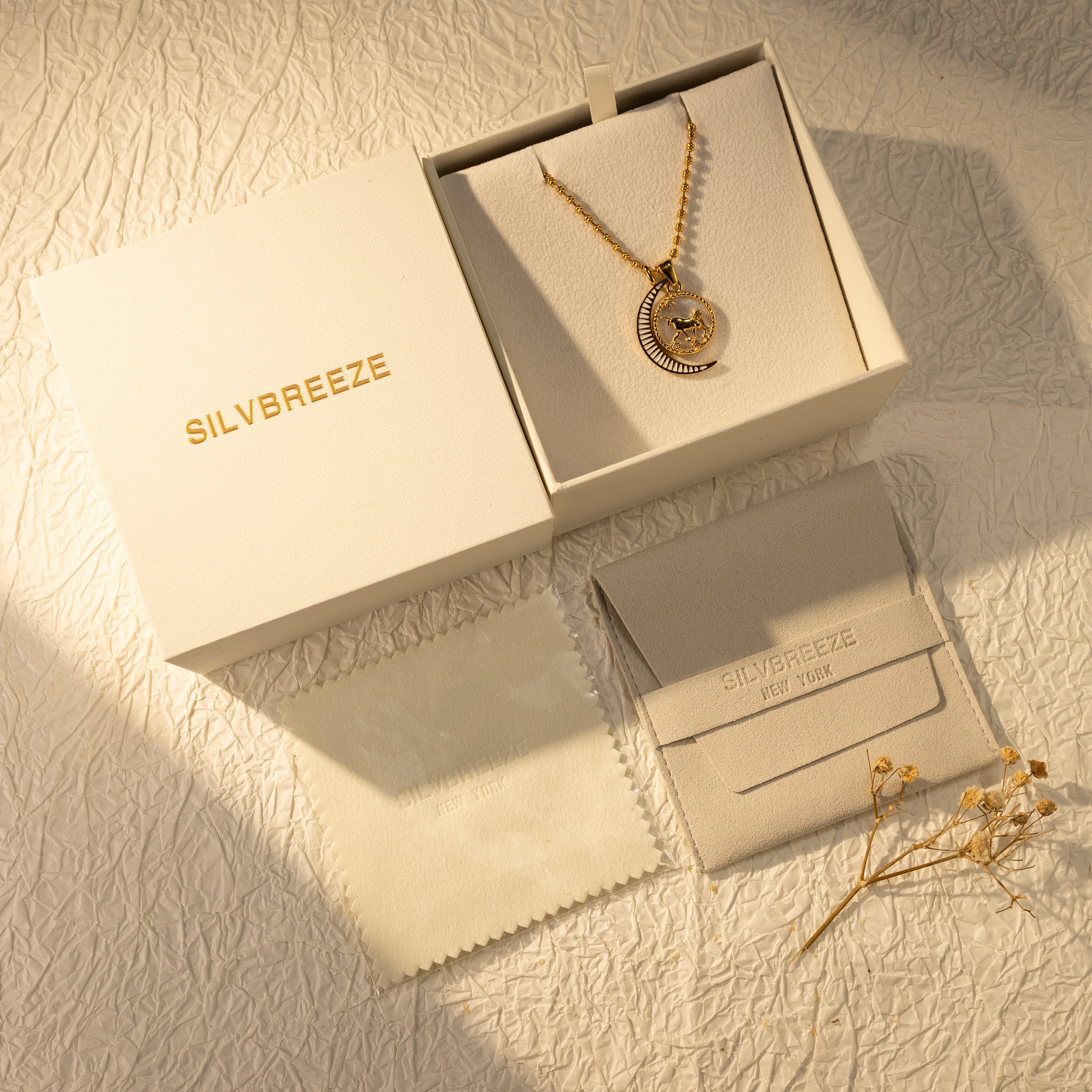 Silvbreeze Lunara Taurus zodiac mother-of-pearl moon necklace displayed in a premium gift box with suede pouch and polishing cloth.