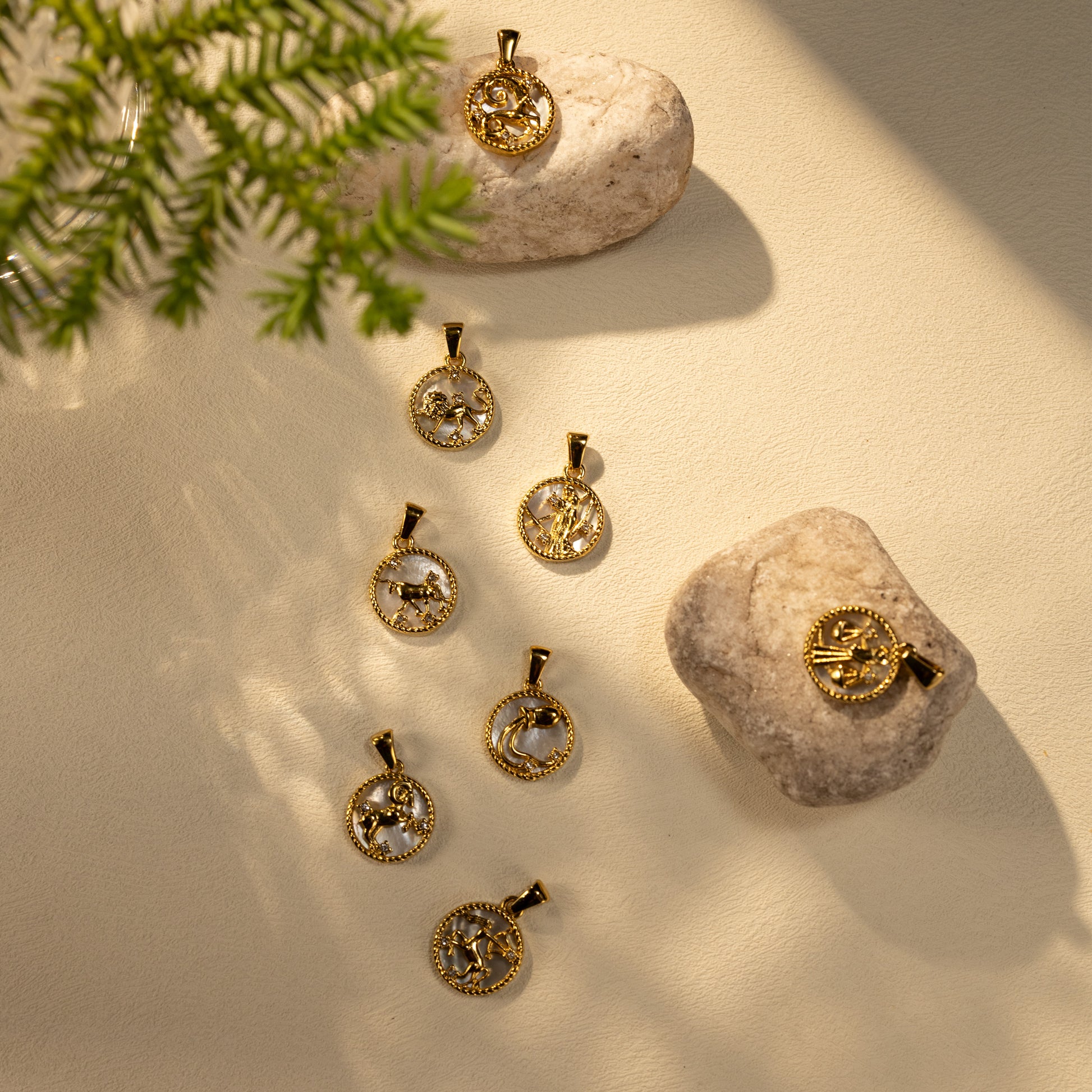 Silvbreeze Lunara zodiac mother-of-pearl pendants arranged on stone and soft light for a natural collection scene.