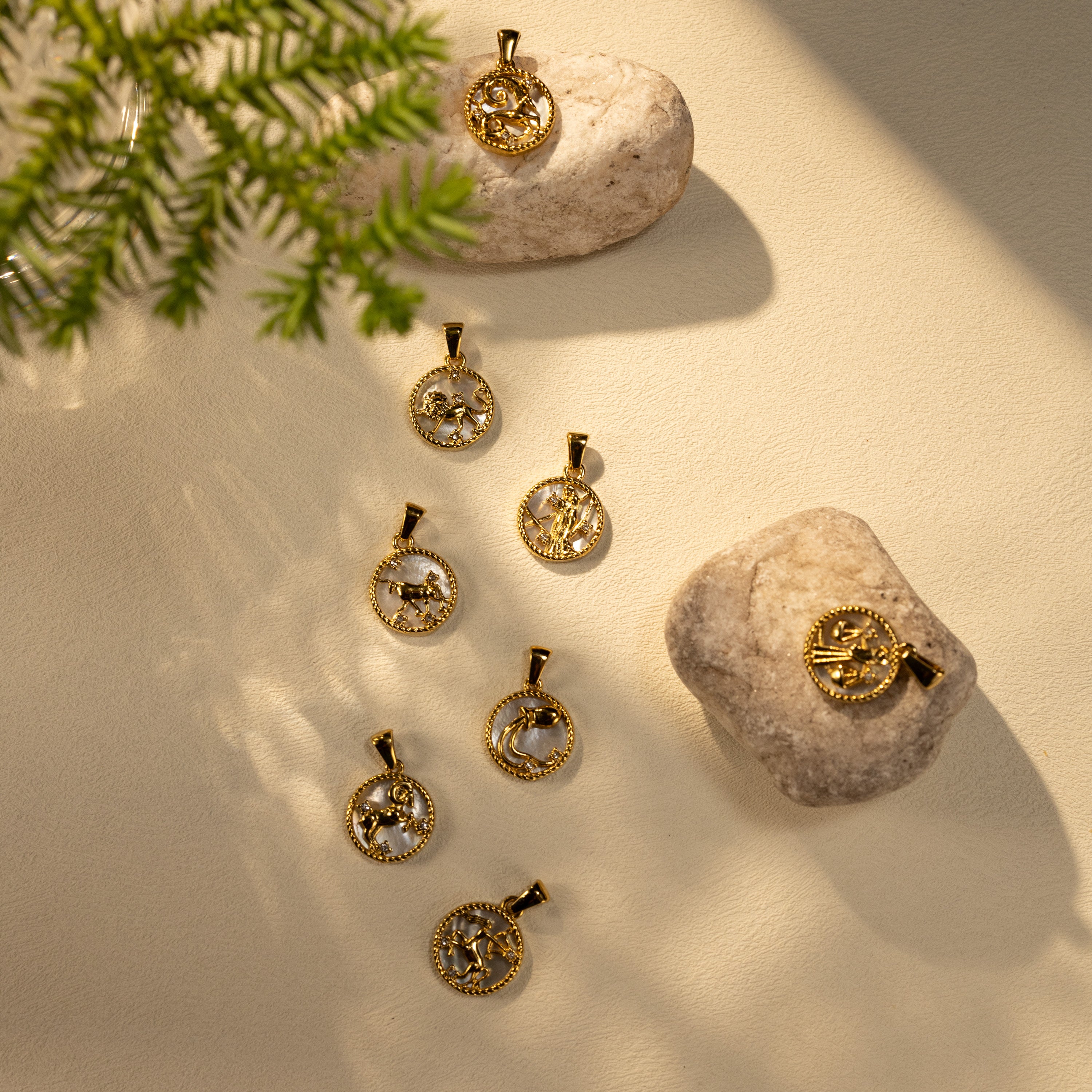 Silvbreeze Lunara zodiac mother-of-pearl pendants arranged on stone and soft light for a natural collection scene.