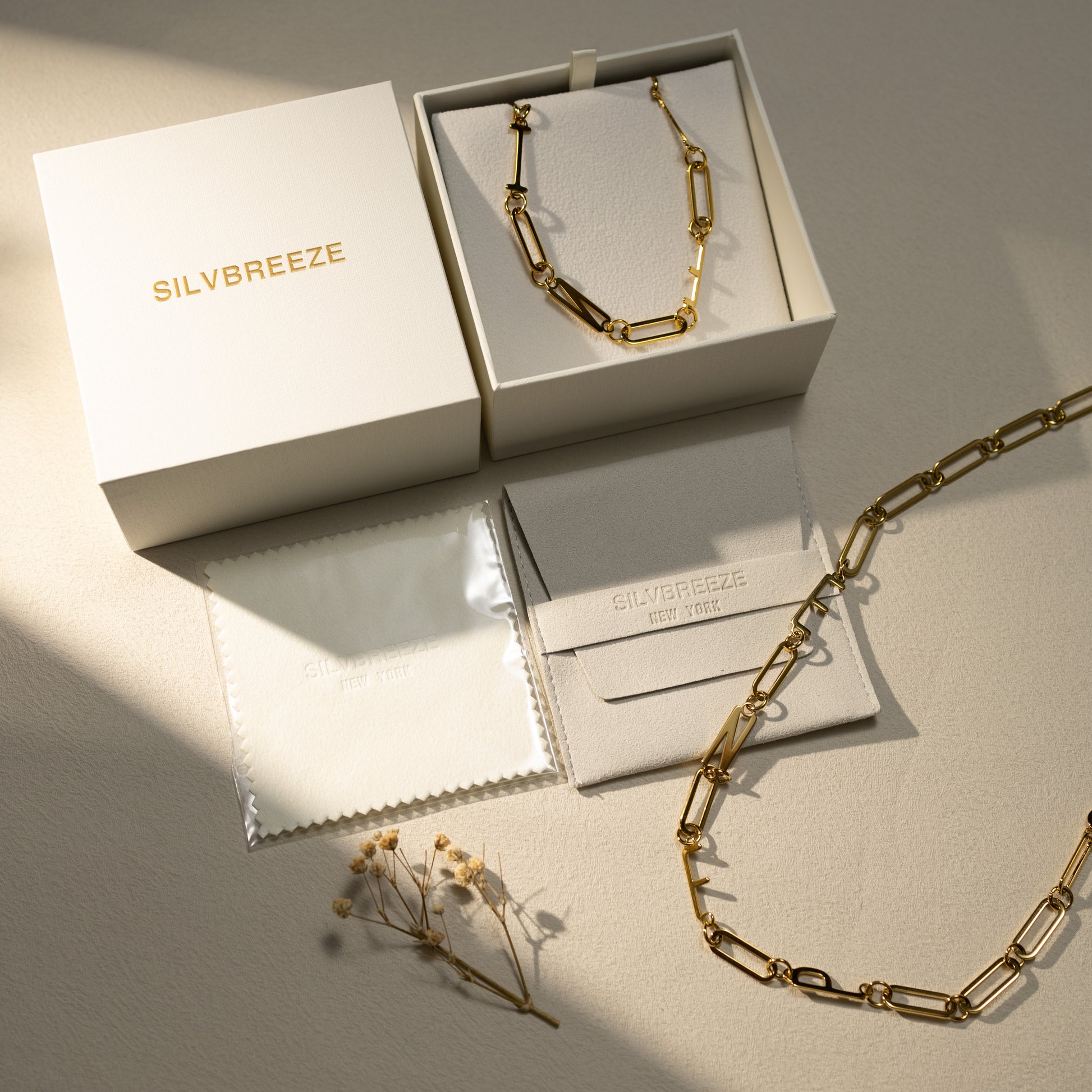 Silvbreeze MBTI 18K gold-plated personality necklaces displayed in a premium gift box set with jewelry pouch and polishing cloth under soft natural light.