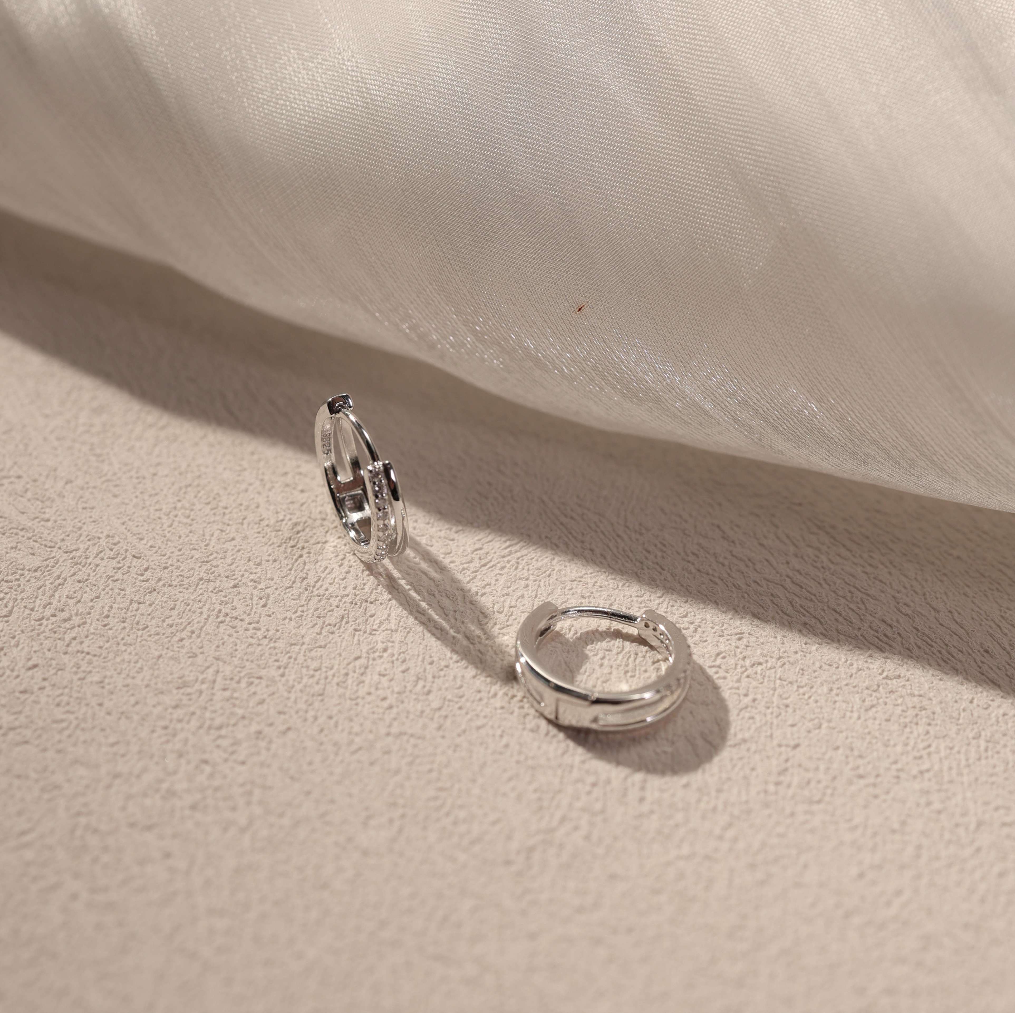 Nira white gold vermeil huggie earrings with cubic zirconia detail, sterling silver small hoop earrings lifestyle photography by SILVBREEZE