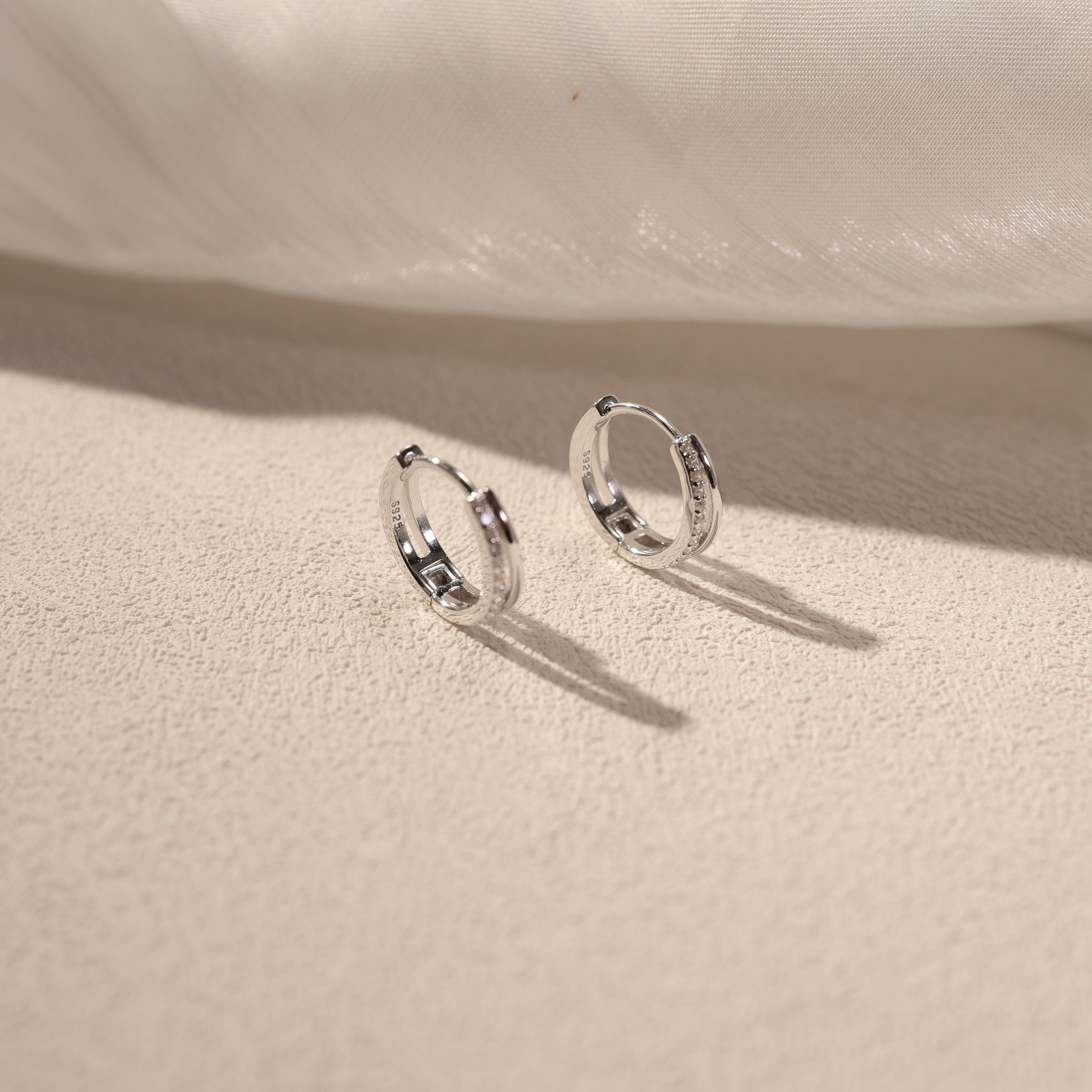 Nira white gold vermeil huggie earrings with cubic zirconia detail, sterling silver small hoop earrings lifestyle shot by SILVBREEZE