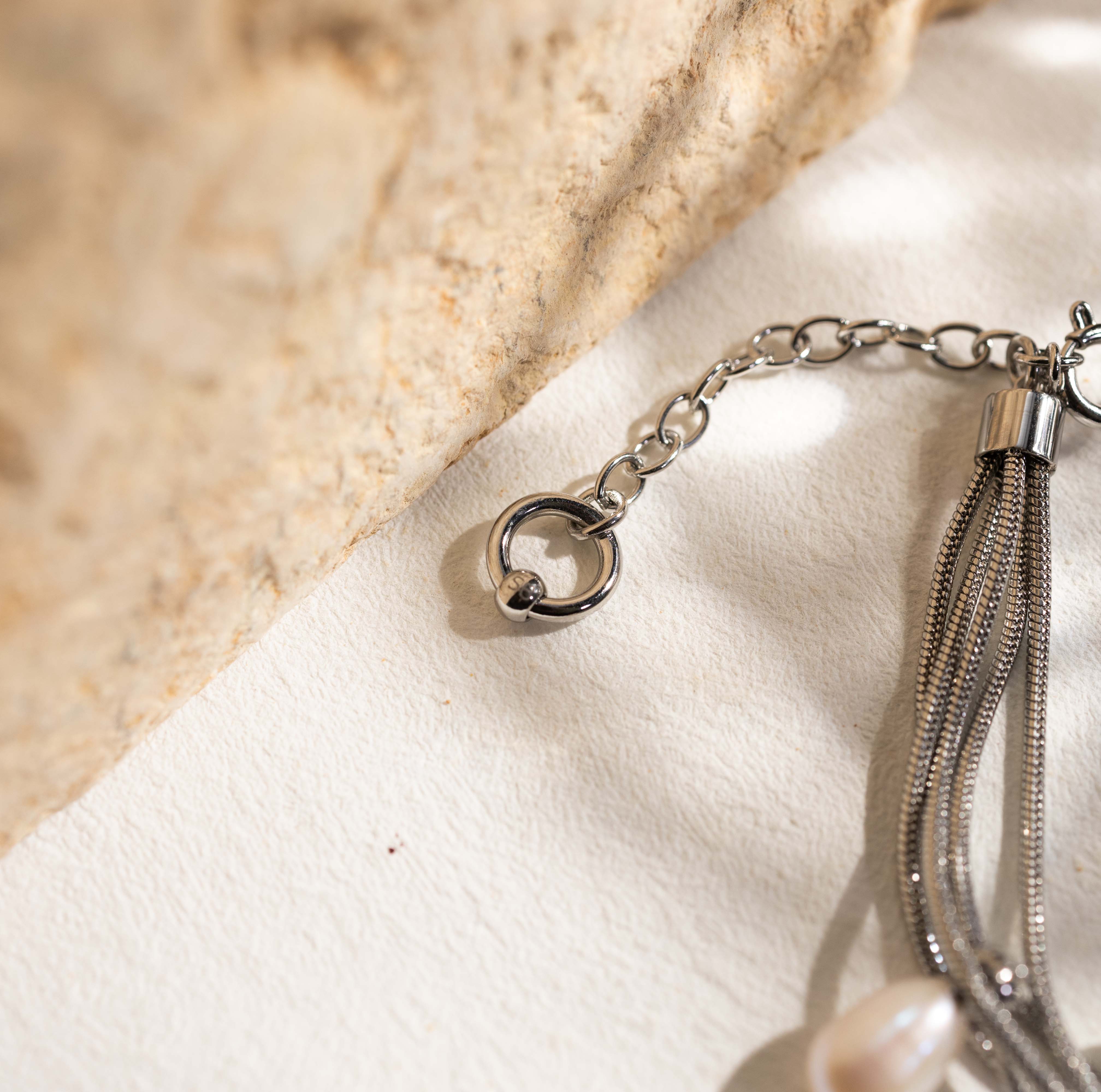 Close-up of Silvbreeze NORN pearl bracelet showing stainless steel snake chains and spring ring clasp detail