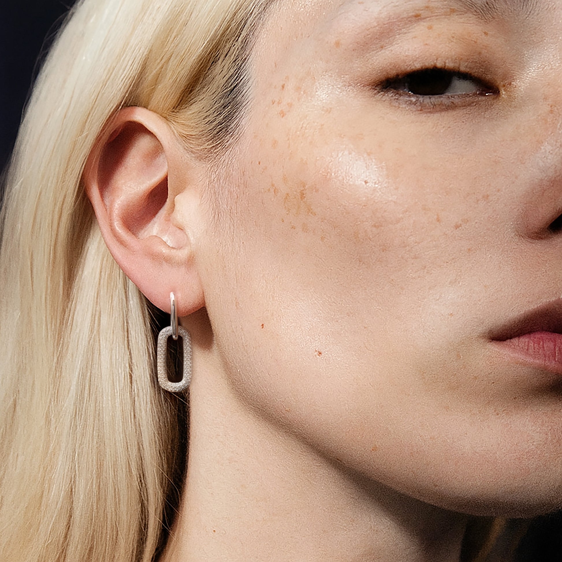 Model wearing the Silvbreeze Ona paperclip drop earrings, showcasing the pavé rectangular link on a close-up portrait.