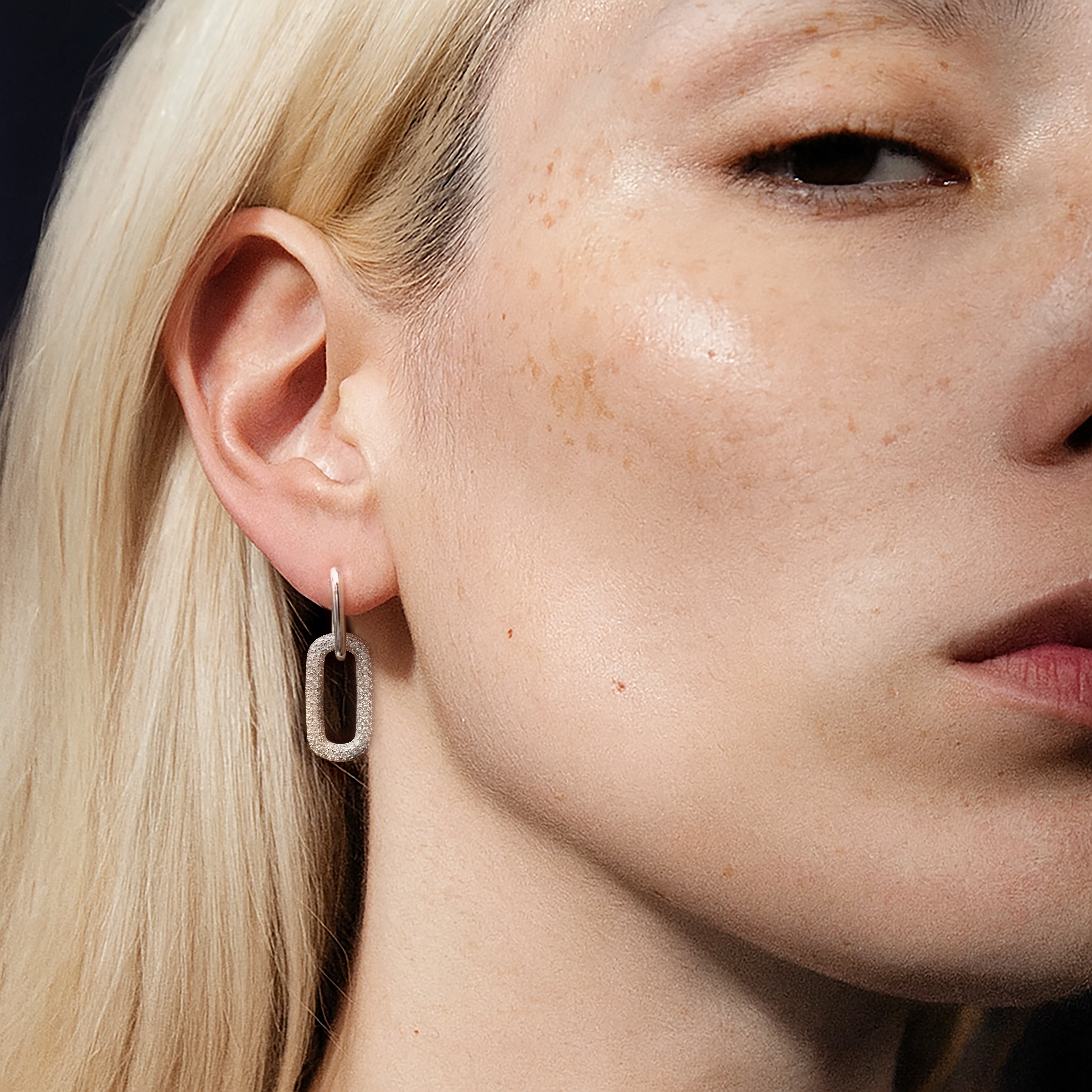 Model wearing the Silvbreeze Ona paperclip drop earrings, showcasing the pavé rectangular link on a close-up portrait.
