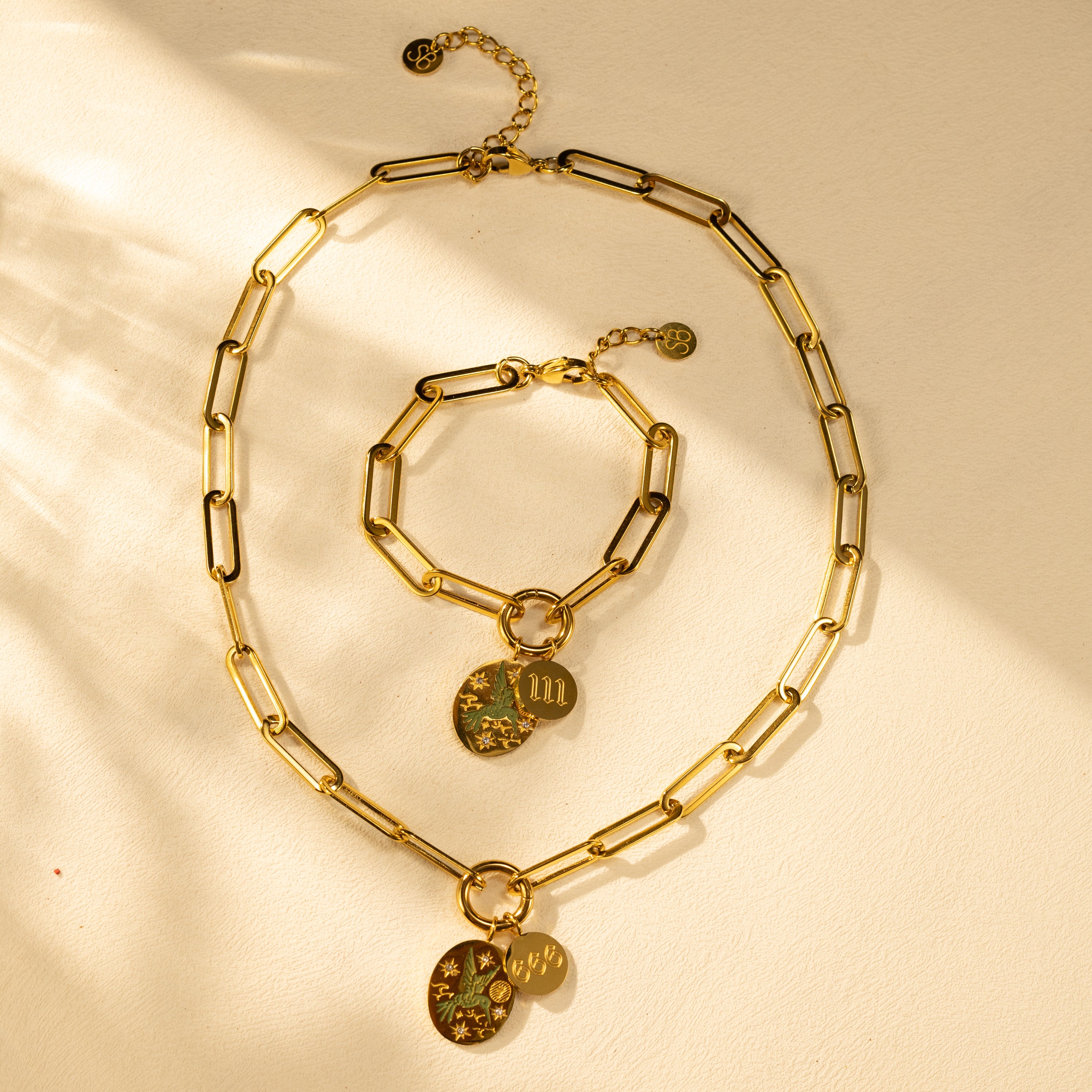 SILVBREEZE paperclip chain necklace and matching bracelet with O-clasp charm holder, 18K gold-plated stainless steel, etched green bird pendant and angel number disc.