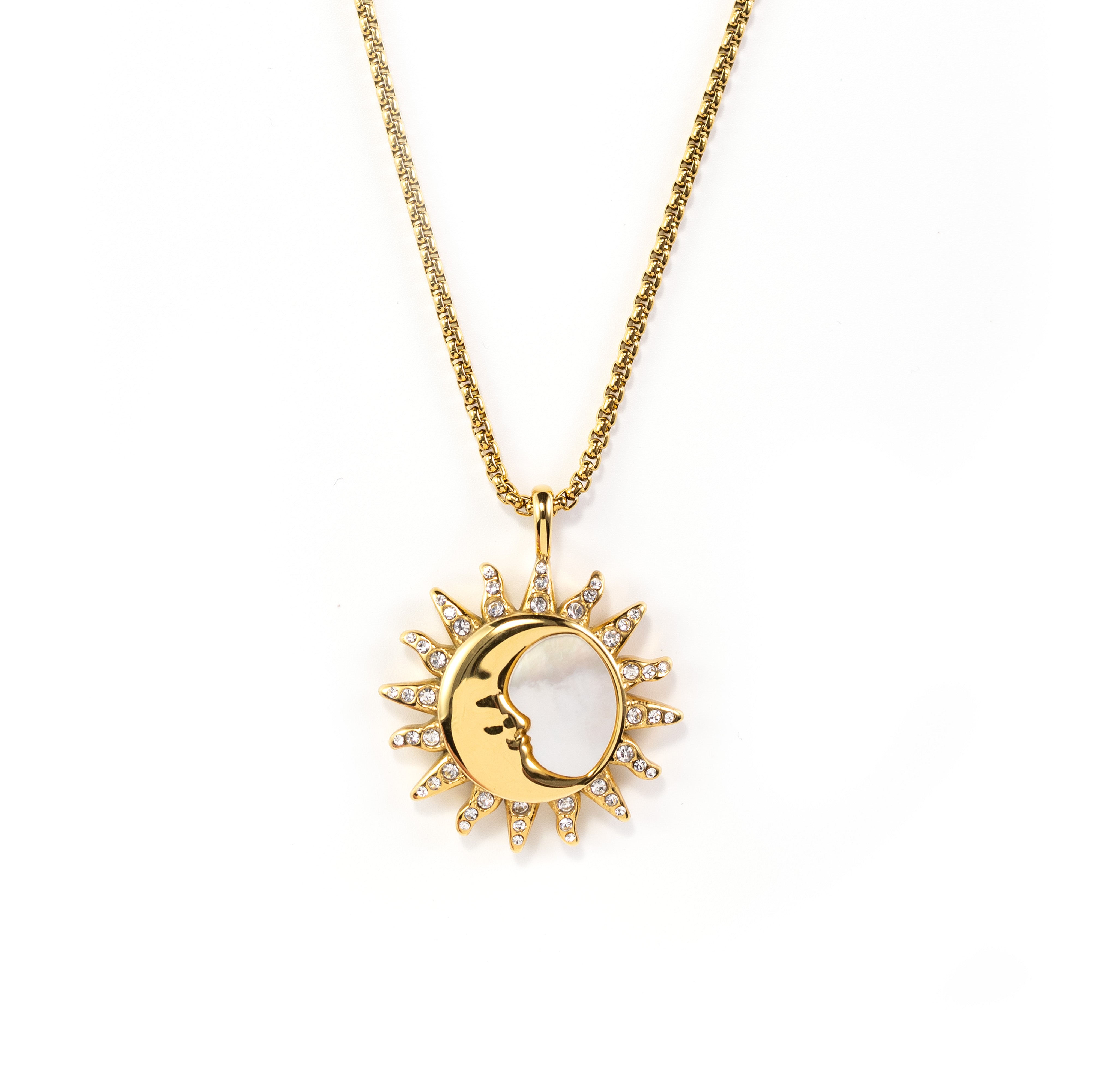 A detailed close-up shot of a high-end gold plated necklace with a combined mystical sun and crescent moon face pendant. The pendant features a mother of pearl crescent moon and pave-set clear crystals on the sun rays, hanging from a gold chain against a pure white background.