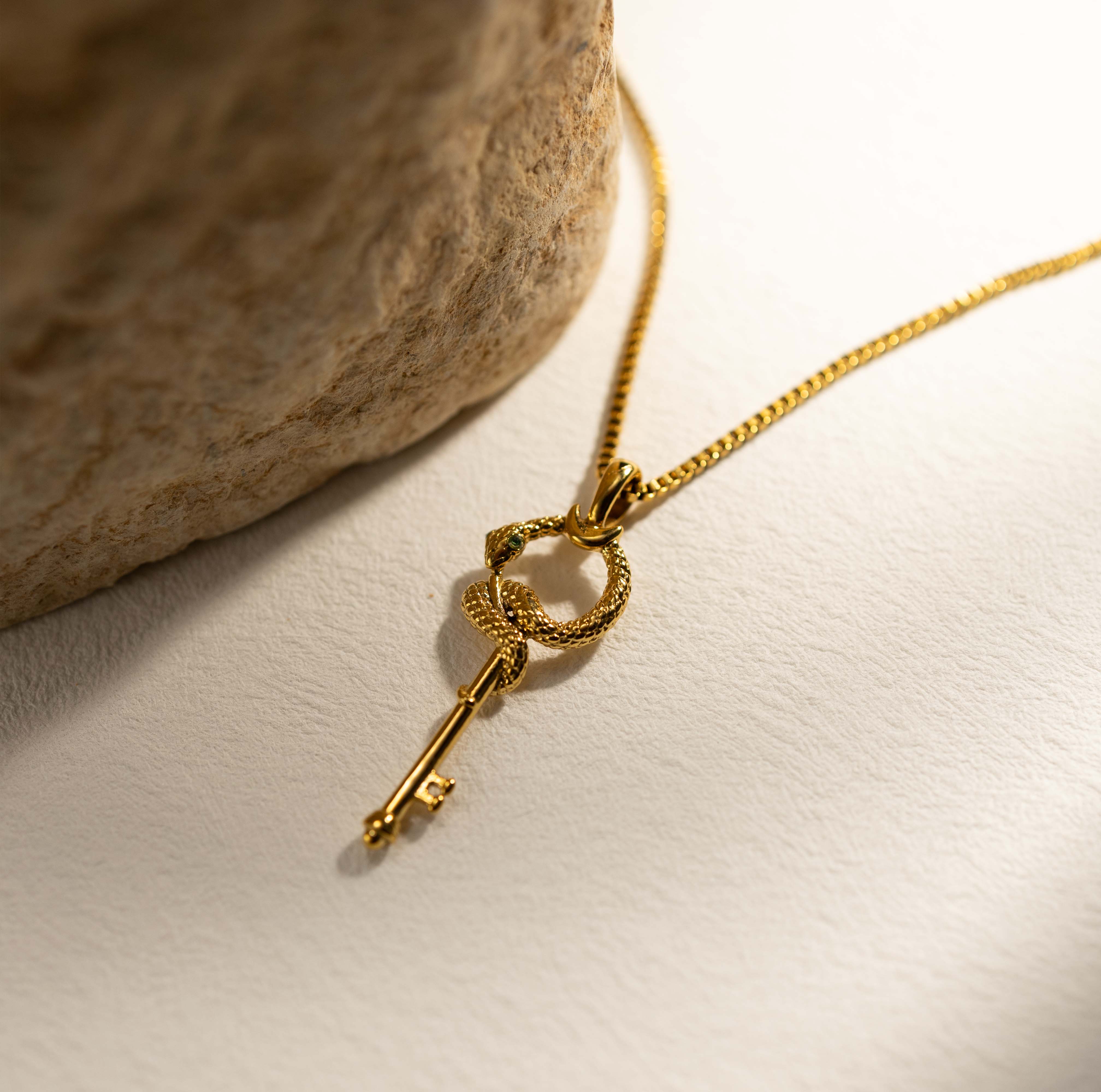 Silvbreeze gold serpent key necklace styled in soft light, captured from a side view to emphasize form and balance